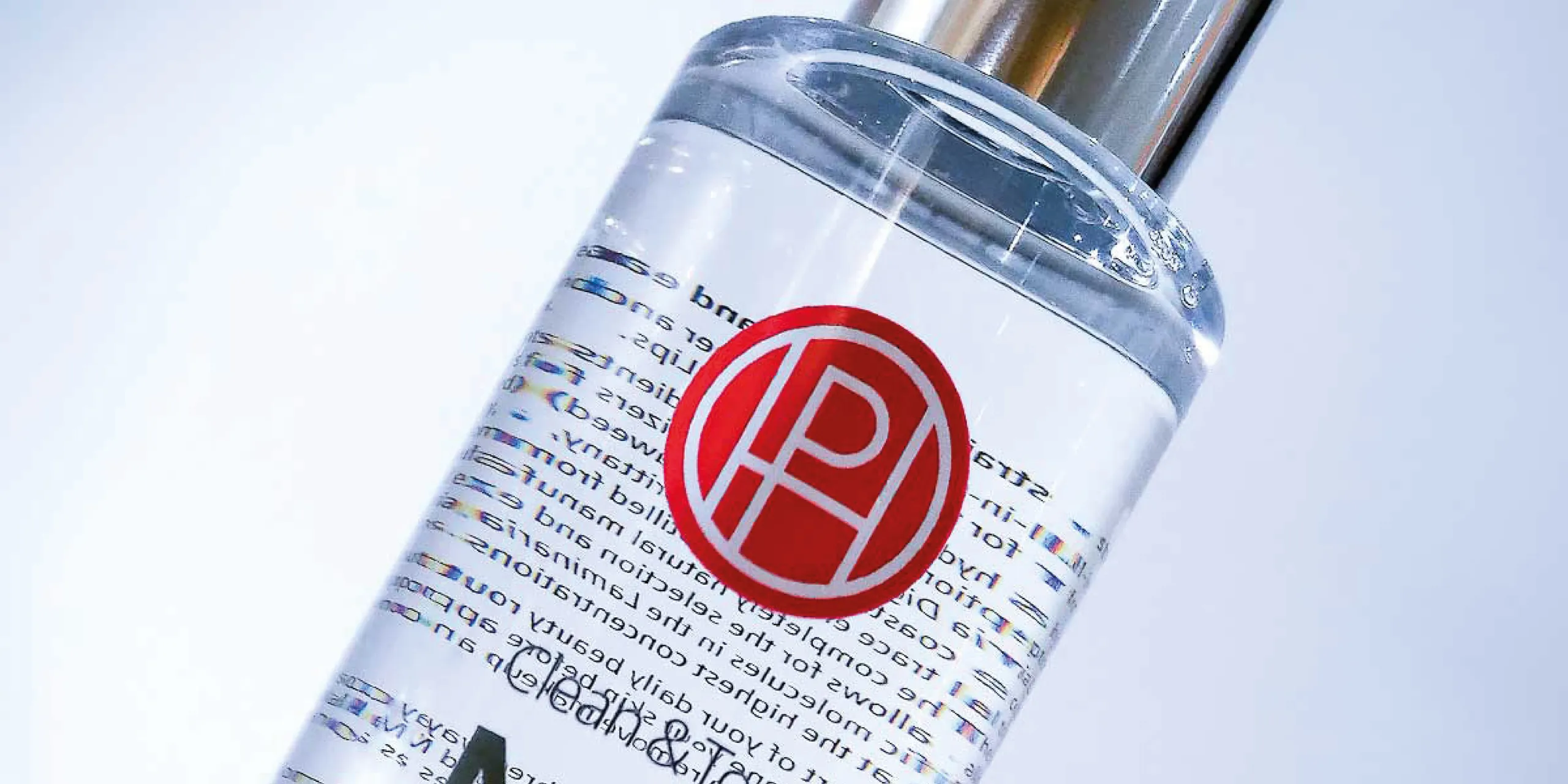 Closeup of a transparent bottle with a red logo and black printing